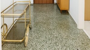 A hallway with a wooden door, a small wooden cabinet, and a metal cart. - Sunny Dream House (Agios Ioannis Rentis)