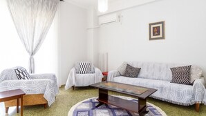 A living room with a sofa, two armchairs, a coffee table, and a patterned rug. - Sunny Dream House (Agios Ioannis Rentis)