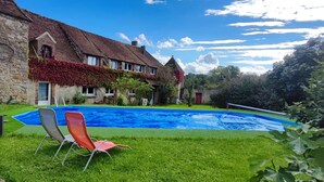 A stone building with a swimming pool and two lounge chairs. - 12th century Manoir des Templiers, with heated swimming pool, jacuzzi, mini golf course  (Trancault)