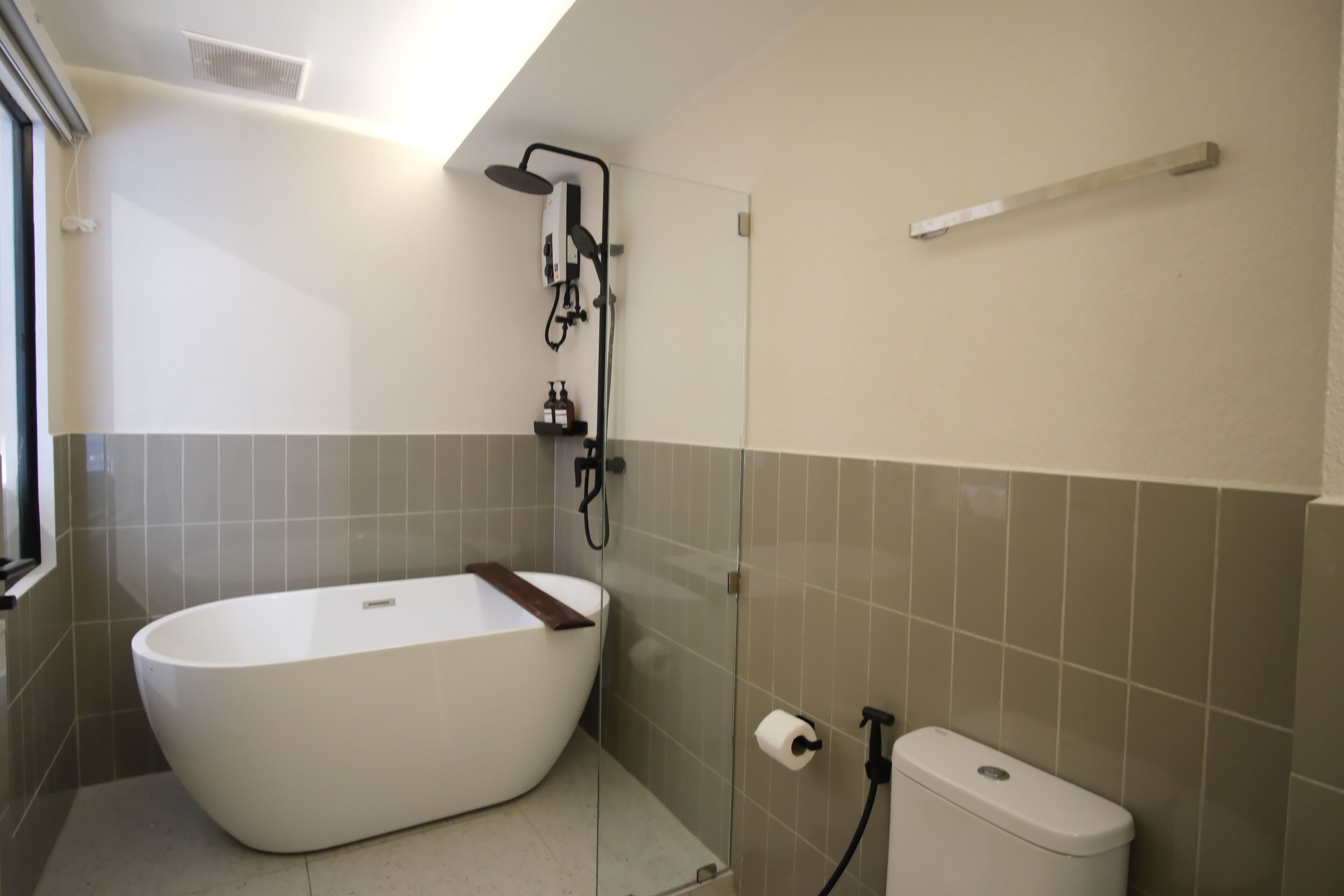 A modern bathroom with a freestanding bathtub, a glass-enclosed shower, and a toilet.