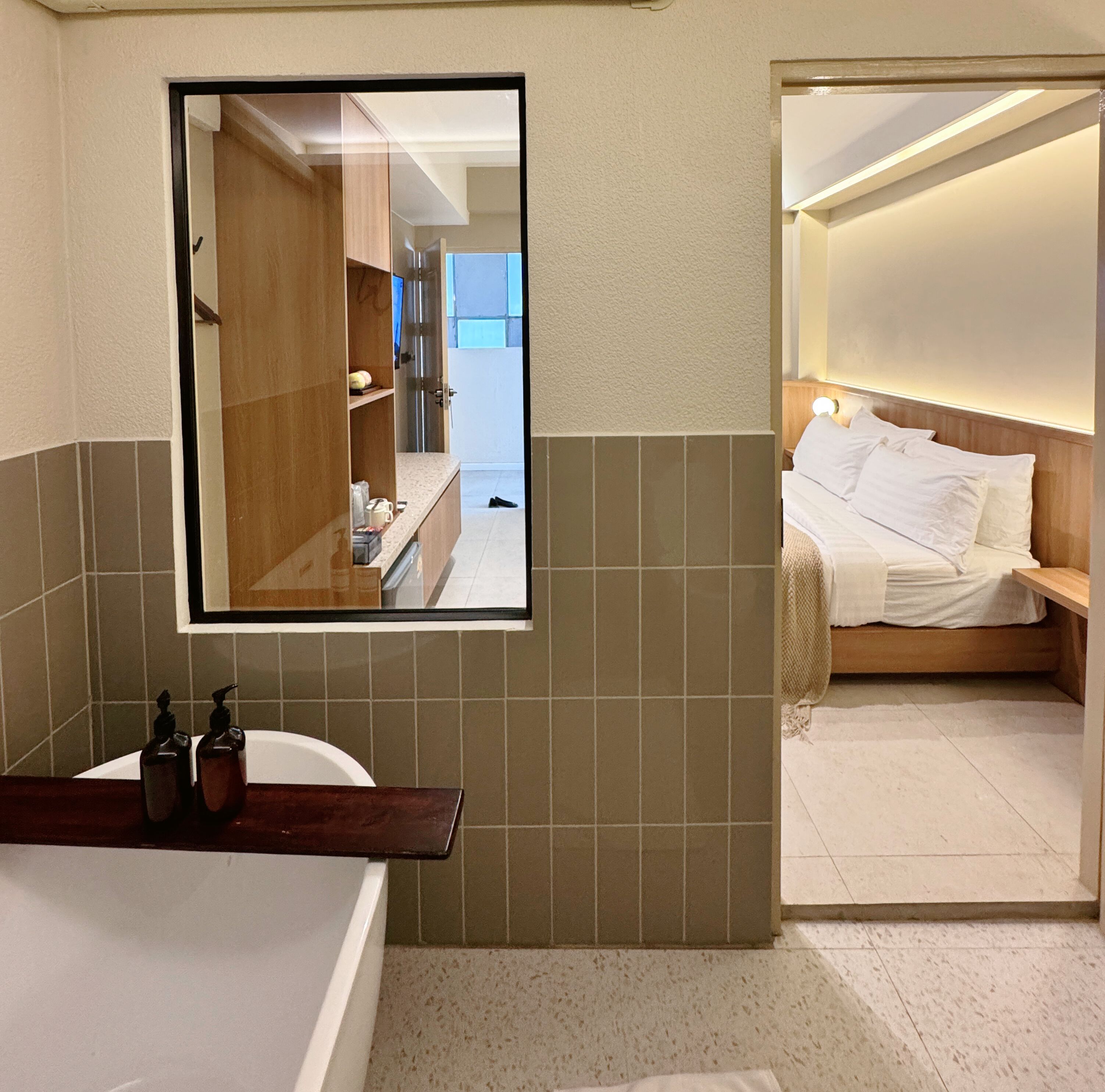 Un baño moderno con un espejo grande, una bañera y una zona de ducha.