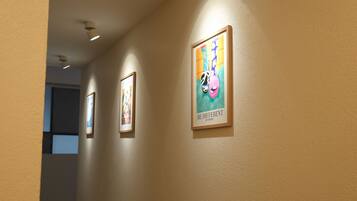 A hallway with framed artwork on the walls and recessed lighting.