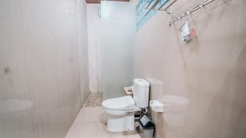 A modern bathroom with a toilet, bidet, and shower.
