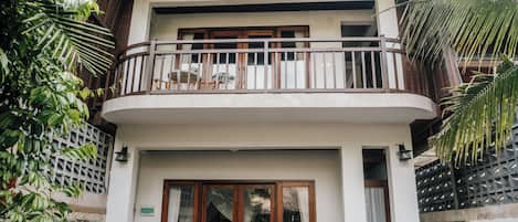 Ein zweistöckiges Haus mit Balkon, Schwimmbecken und einem Flamingo-Schwimmpferd.