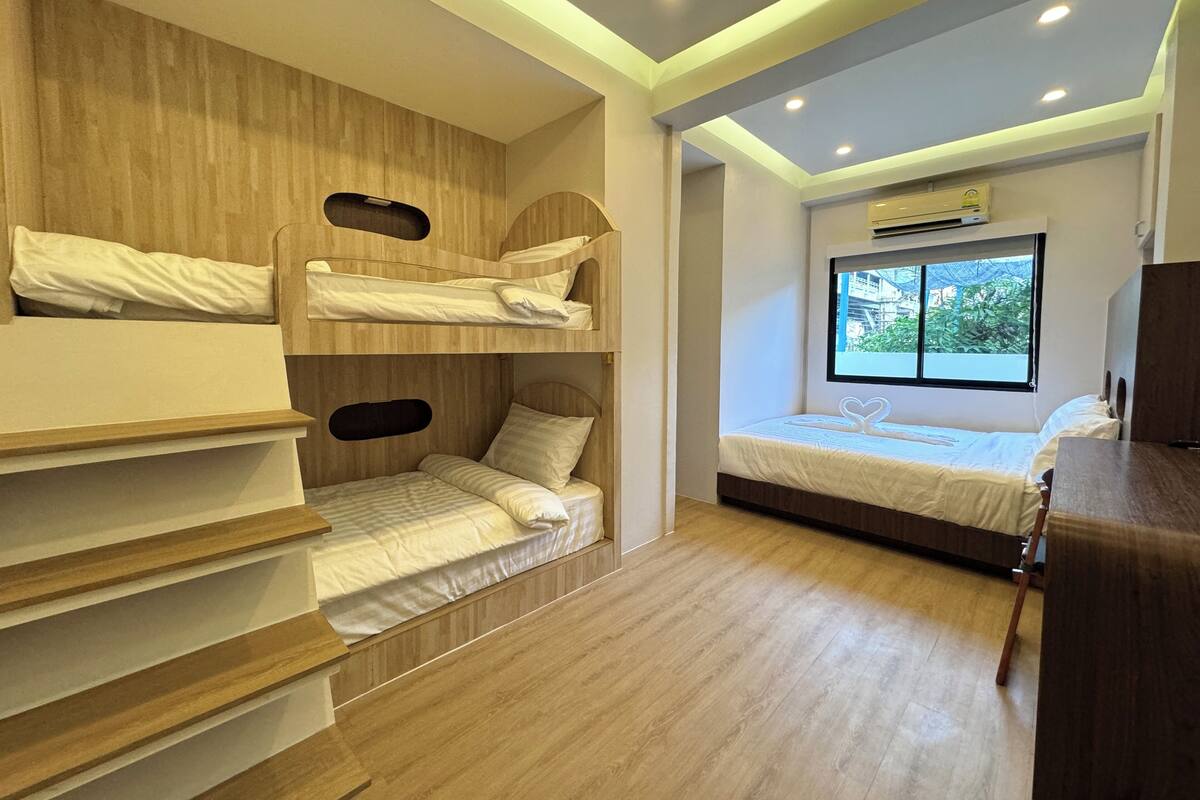 Ein Zimmer mit Etagenbetten, einem Fenster mit Blick und einer Klimaanlage.