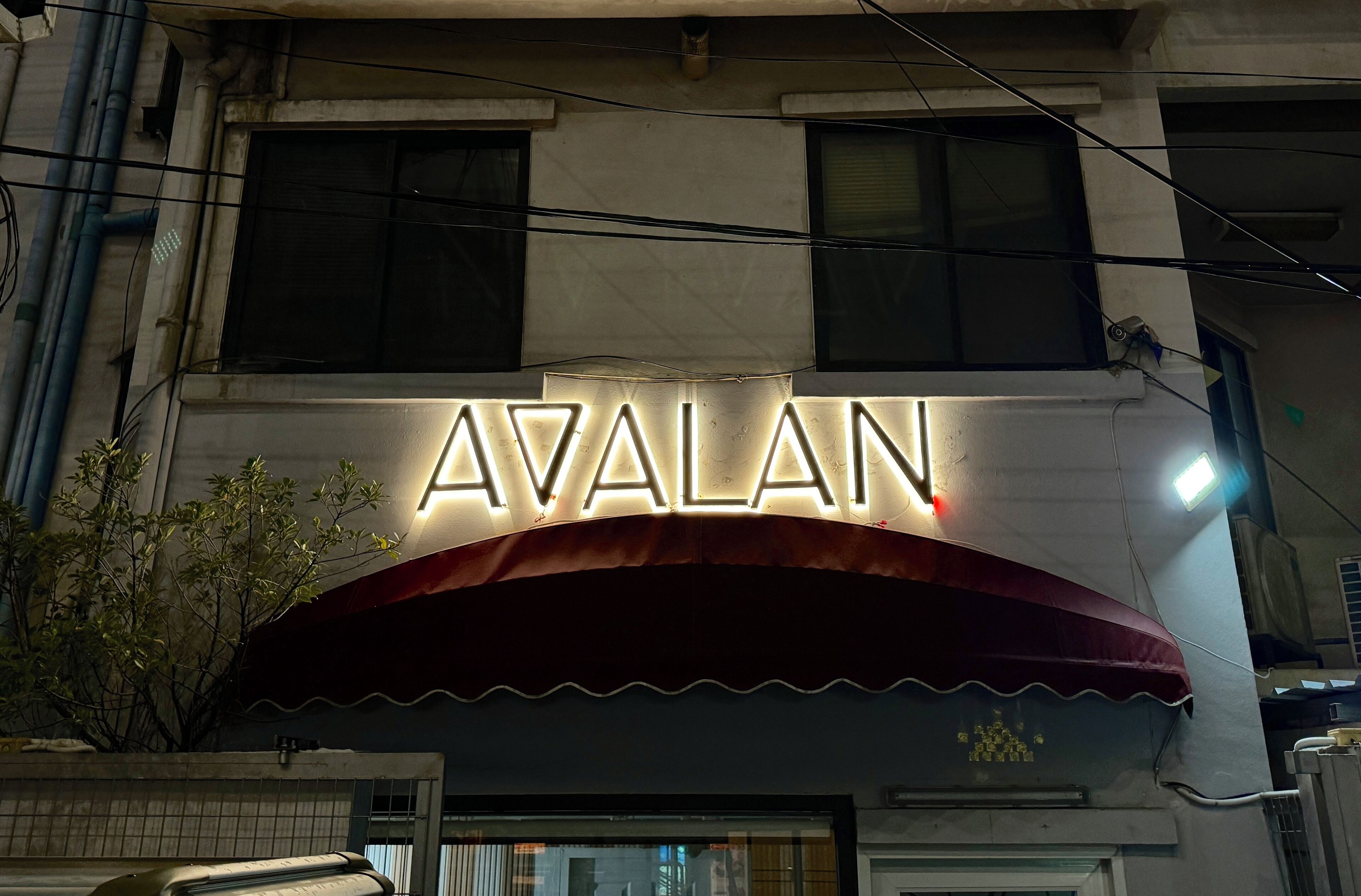 A building with a marquee sign that reads "AVALAN".