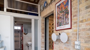 Ein modernes Interieur mit Treppe, einem Badezimmer mit gemusterten Fliesen und einem gerahmten Kunstwerk an der Wand.