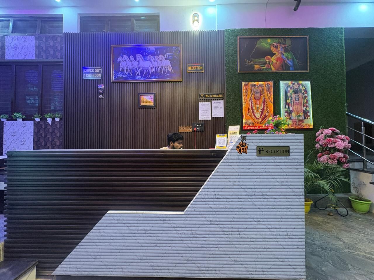 A reception area with a check-out counter, a reception desk, and a wall with framed artwork.