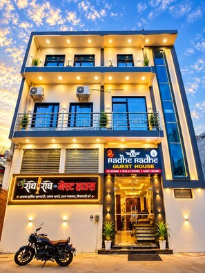 A two-story building with a sign for 'Radhe Radhe Guest House' indicating it offers AC, non-AC, and family rooms. - Shri Radhe Radhe Paying Guest House (Faizabad)