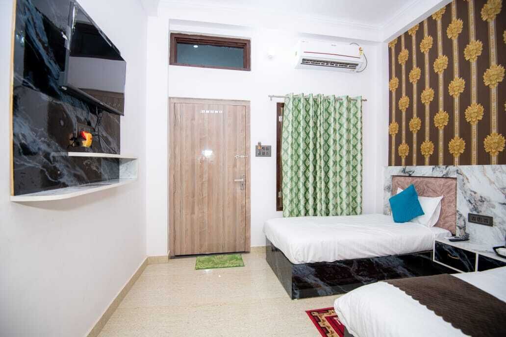 A bedroom with a bed, a wardrobe, a small window, and an air conditioning unit.