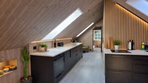 Una cocina moderna con tragaluz, detalles de madera y una isla central.