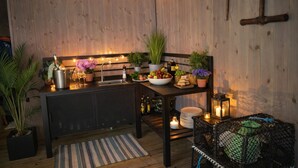 Una cocina acogedora con paredes de madera, una isla central con pileta y diferentes plantas y utensilios de cocina.