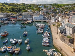 A harbor with numerous boats docked, surrounded by a town with historic buildings.