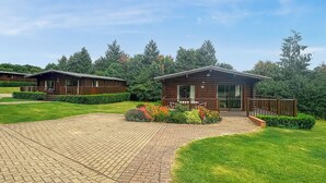 A lodge with a paved driveway, wooden cabins, and a well-maintained garden. - 1 bedroom accommodation in Greetham (Greetham)