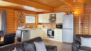 A log cabin interior with a dining area, kitchen, and seating area. - 1 bedroom accommodation in Greetham (Greetham)