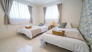 A hotel room with two single beds, each with a basket and a nightstand. - Guest House Terrace (Miyakojima)