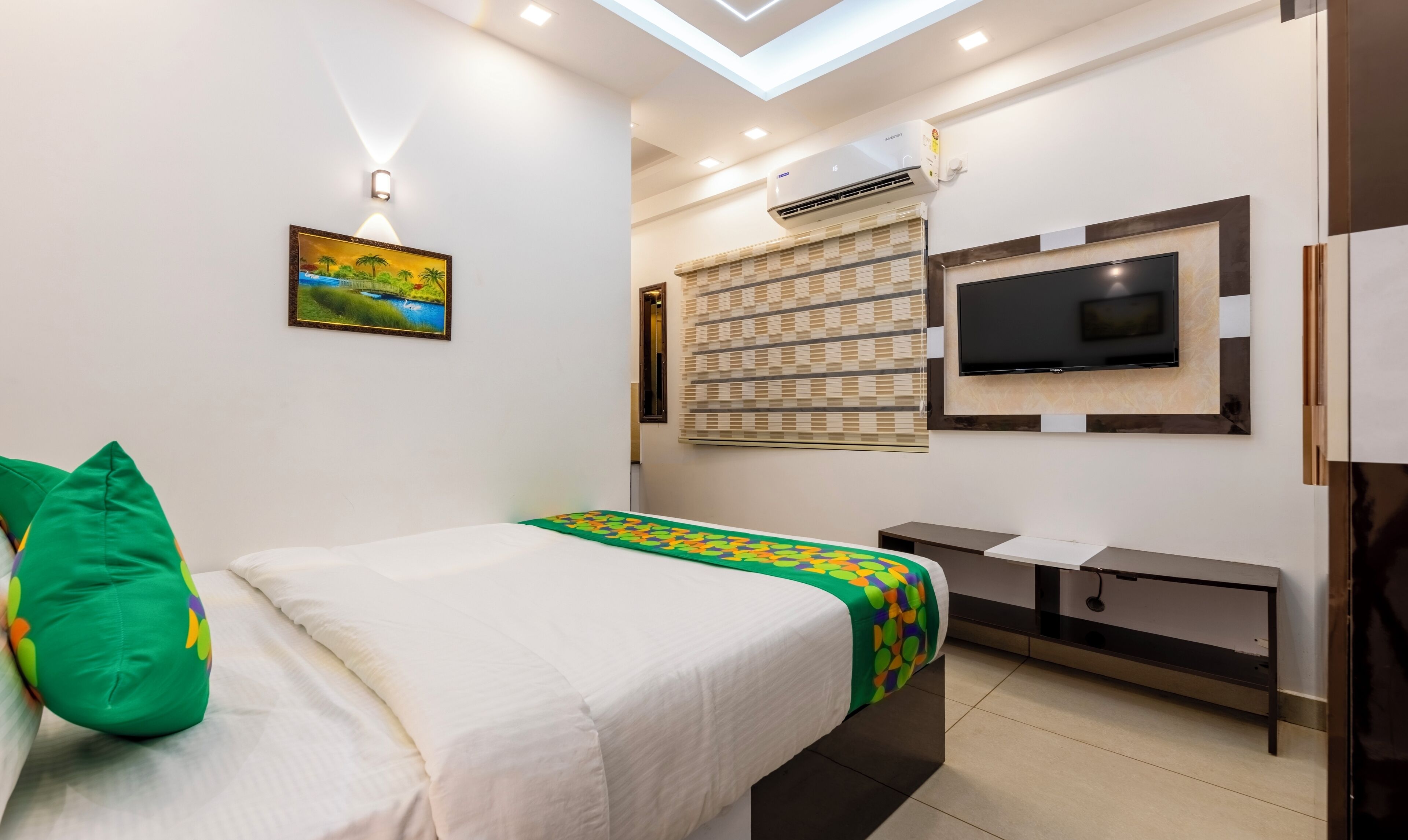 Une chambre d’hôtel moderne équipée d’un lit, d’une télévision et d’un système de climatisation.
