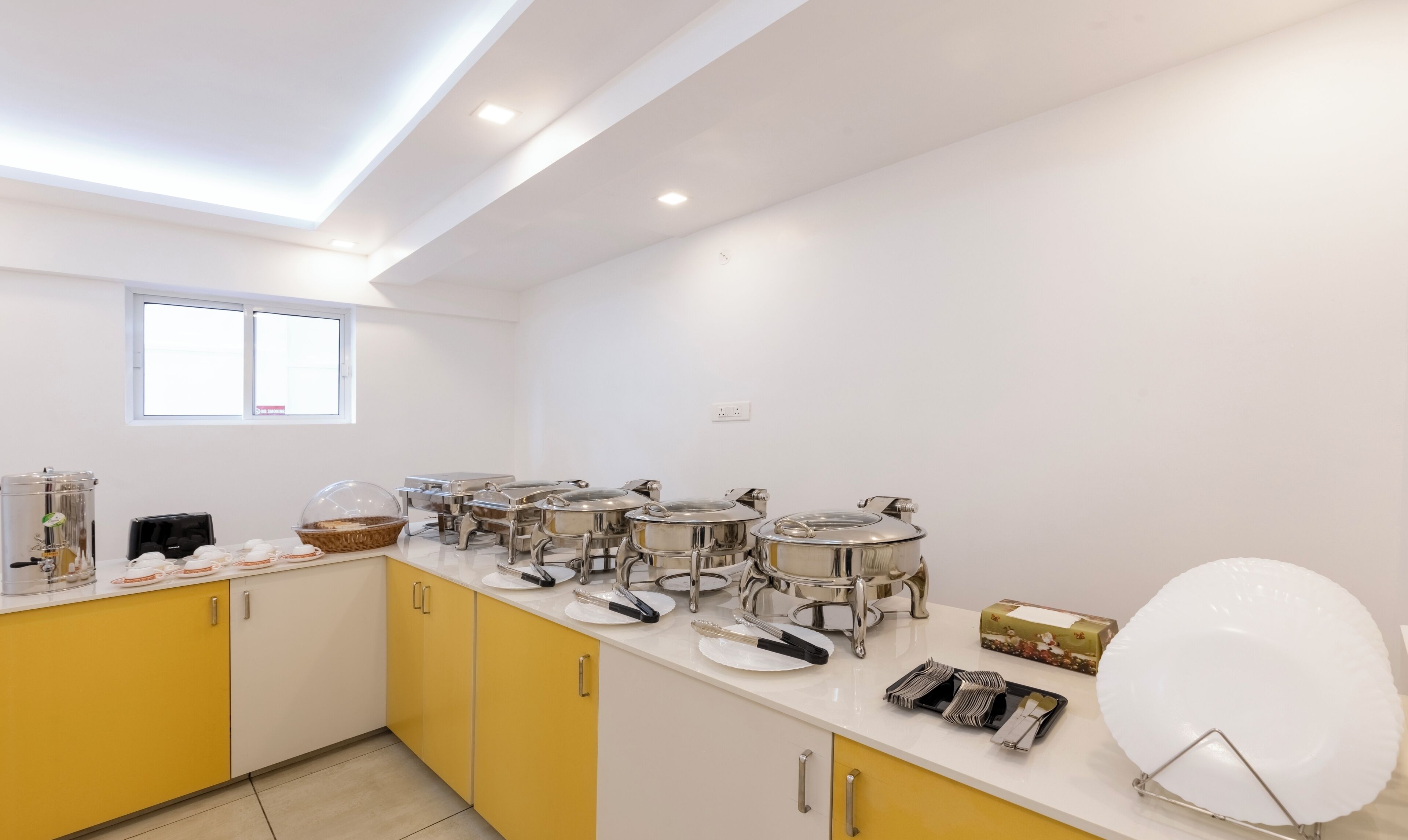 Una cucina moderna con mobili gialli, elettrodomestici in acciaio inossidabile e diversi utensili per la preparazione del cibo.