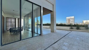 A modern building with large glass doors leading to an outdoor patio area.