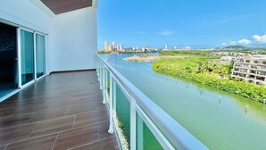 Un balcon avec vue sur une rivière et sur le paysage urbain.