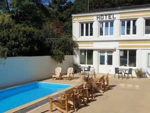 A hotel with a pool, outdoor seating, and a two-story building. - Suite for 3        . (Saint-Jean-de-Monts)