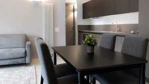 Eine moderne Küche mit dunklen Schränken, einer schwarzen Arbeitsplatte und einem Blumentopf.