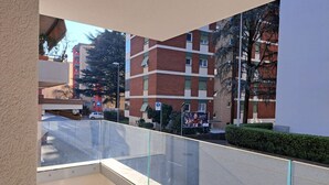 A balcony with a clear view of a multi-story building with a red brick facade and green window frames. - Cosy bilo close to the centre (Urban 4) (Lugano)