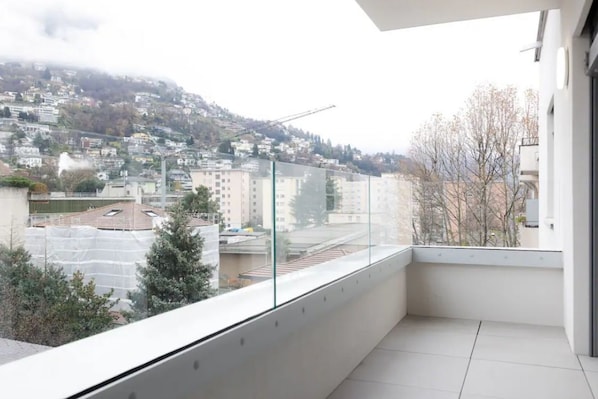 A balcony with a view of a residential area and a construction site.