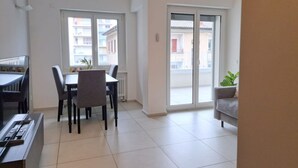 A modern apartment with a dining area, a sofa, and a sliding glass door to the outside. - Cosy bilo close to the centre (Urban 5) (Lugano)