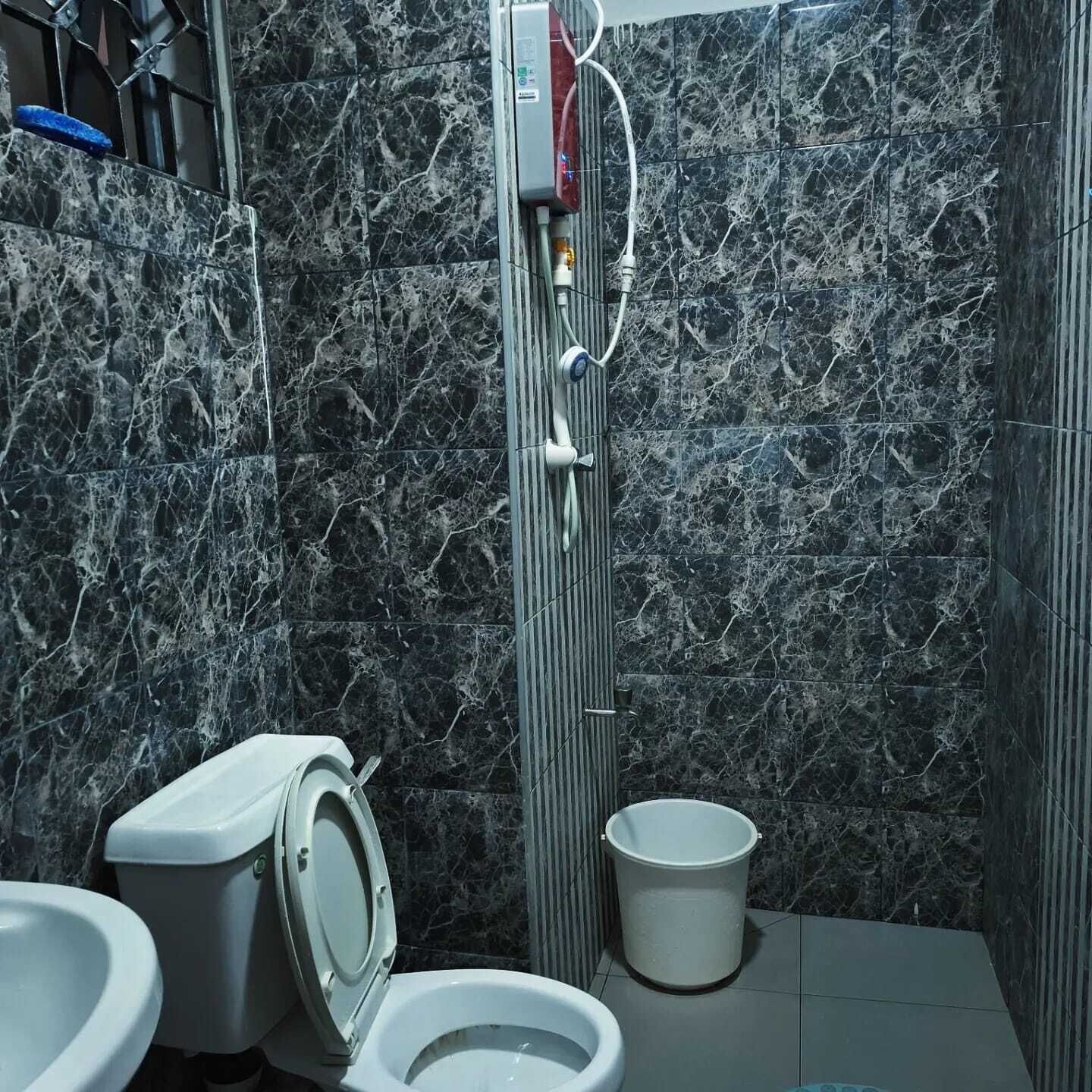 Ein Badezimmer mit Toilette, Bidet und Eimer.