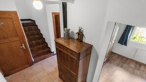 A room with a wooden dresser, a window with a view, and a staircase. - Pretty chalet-style studio (Euseigne)