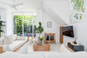 Una sala de estar moderna con un sofá, una mesa de centro y un televisor.