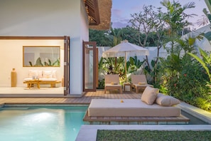 A poolside area with a sofa, chairs, and a table. - Villa Lounes 2 (Tabanan)