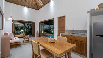 A modern kitchen with a dining area, a large vase, and a view of the outdoors.