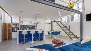 Eine moderne Wohnung mit Küche, Essbereich und einer Treppe zu einer oberen Ebene.