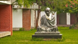 A statue of a seated figure in a garden setting. - HOTEL GREEN TREE (Ahmedabad)