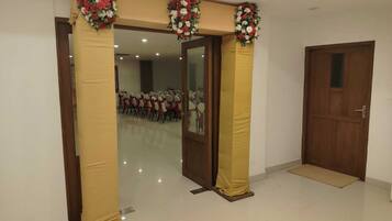 A room with a door, a mirror, and a tiled floor.