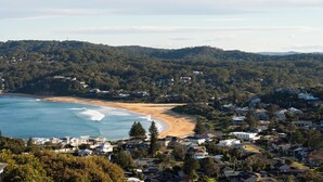 A coastal residential area with houses, a beach, and a forested hillside. - “Sunrise & Sunset” – Panoramic Ocean Views (Copacabana)