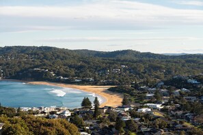A coastal residential area with houses, a beach, and a forested hillside. - “Sunrise & Sunset” – Panoramic Ocean Views (Copacabana)