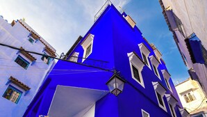 Eine enge Straße mit einem blauen Gebäude, das eine Tür und Fenster zeigt.
