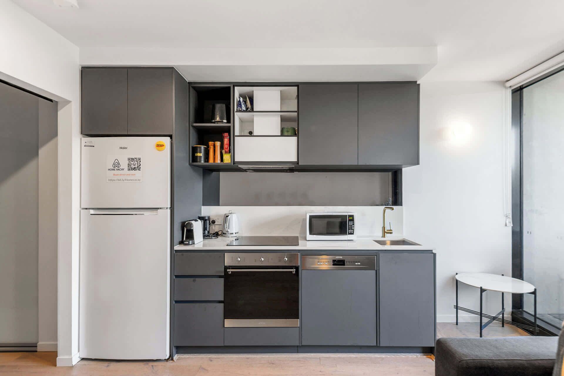 A modern kitchen with a built-in oven, microwave, and dishwasher.