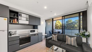 Un apartamento moderno con cocina, comedor y sala de estar con sofá y mesa de centro.