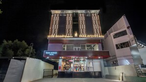 Um hotel com fachada moderna, letreiros iluminados e entrada visível.