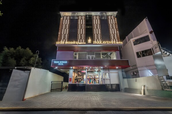 A hotel with a modern facade, illuminated signage, and a visible entrance.