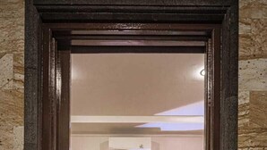 Ein Hotelzimmer mit Bett, Nachttisch und einem durchgegangenen Tür sichtbaren Badezimmer.