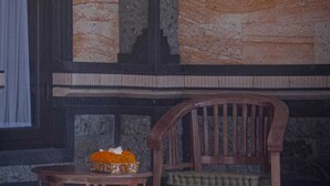 Ein Zimmer mit einem Holzstuhl und einem kleinen Tisch, beide mit schlichtem Design.