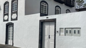 En vit byggnad med en stor dörr märkt med siffran "50" och ett litet fönster med texten "AL".