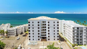 Un hôtel moderne à plusieurs étages, doté d’une entrée principale, d’un parking et offrant une vue sur l’océan.