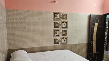 Cama bem arrumada em quarto com parede texturizada e ventilador de teto.
