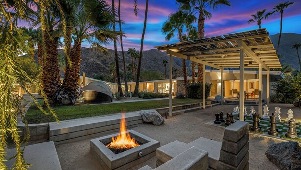 A modern outdoor patio with a fire pit, seating area, and chess set. - Luxury Palm Springs Estate 3Bedroom House & 3 Casitas, Salt Water Pool & HotTub (Palm Springs)